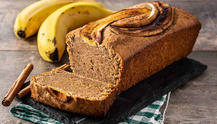 Freshly Baked Banana Bread Freshly baked golden-brown banana bread loaf resting on a wooden cutting board